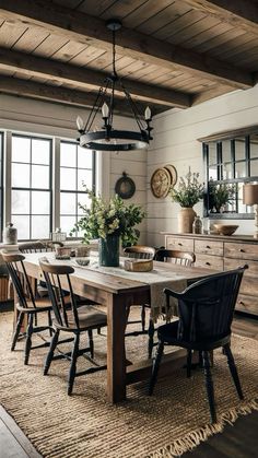 the dining room table is surrounded by chairs and vases with flowers on them,