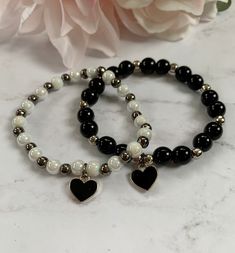 "Beautiful stretch bead bracelets with black heart charms. The bracelets shown are made with (1) 6mm white marble glass and 5mm gunmetal beads and (2) 8mm black onyx glass and 5mm silver metal beads. Both have a silver and black heart filled charm. This listing is for one bracelet with one charm. If you're looking for another color, send me a message! The bracelets shown are approximately 7\" in length." Gold Bead Bracelets, Bead Charm Bracelet, Bead Bracelets, Jewelry Outfit, Dangle Charms, Heart Beads, Black Heart, Sterling Silver Heart, Metal Beads