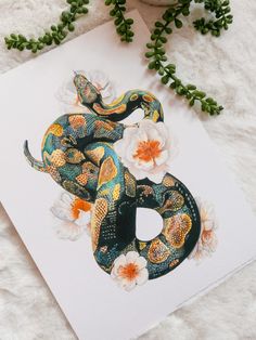 a painting of a snake with flowers on it's back and the letter b in the middle