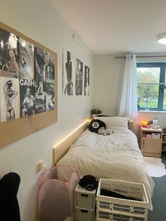 a bed room with a neatly made bed and lots of pictures on the wall above it