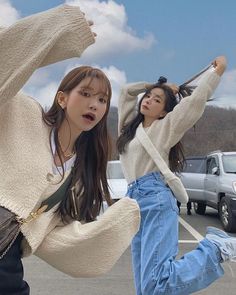 two young women standing next to each other in a parking lot