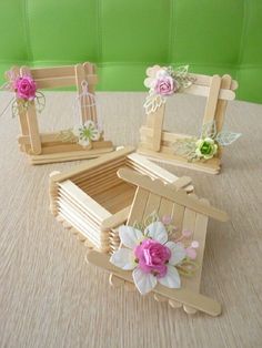 three wooden frames with flowers on them sitting on a table