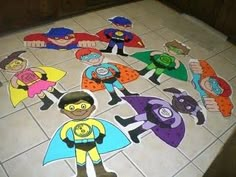 the children are dressed up as superheros on the floor