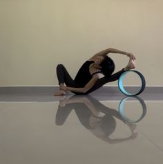 a woman is sitting on the floor with a frisbee in front of her