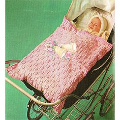 a baby in a stroller with a blanket on it's back and the cover is pink