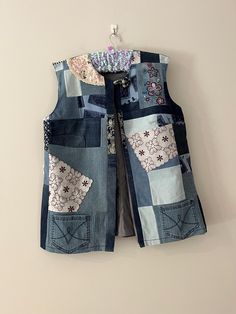 This beautiful size 18 sleeveless denim jacket is not one of my most recent creations.  After finding a forgotten box of clothing made in my early days of creating, I am so excited to give someone the opportunity to feel beautiful in this long line jacket. This has been created from preloved denim pieces and vintage doilies. The style is relaxed and has one closure with a covered button and loop at the neckline. This jacket is fully lined and features original denim pockets.  The hemline finishe Sleeveless Denim Blue Cotton Outerwear, Casual Cotton Patchwork Vest, Fitted Cotton Patchwork Denim Vest, Fitted Cotton Denim Vest With Patchwork, Fitted Patchwork Denim Vest, Casual Cotton Denim Vest With Patchwork, Cotton Patchwork Vest For Spring, Spring Cotton Patchwork Vest, Spring Patchwork Cotton Vest