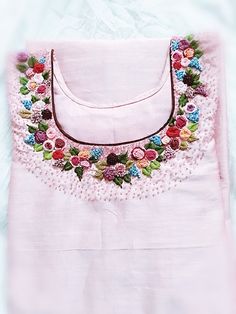 an embroidered pink shirt with flowers on it