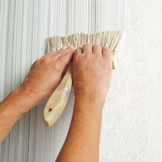 a person is cleaning the wall with a brush