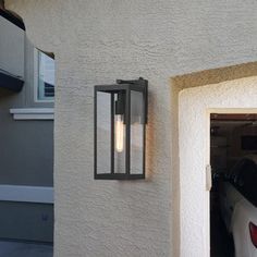 a car is parked in front of a house with an open garage door and two lights on it