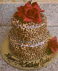 a leopard print cake with red roses on top