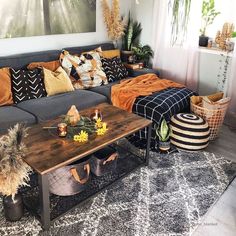 a living room filled with lots of furniture and decor on top of carpeted flooring