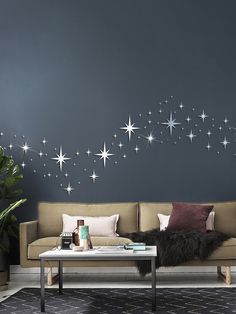 a living room filled with furniture and stars painted on the wall above it's coffee table