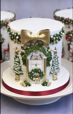 a white cake decorated with green and gold decorations on top of a plate next to other plates