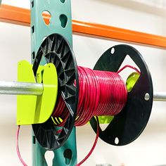 a spool of red and green wire is attached to a rack with reels