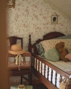 a small child's bedroom with floral wallpaper and teddy bears on the bed