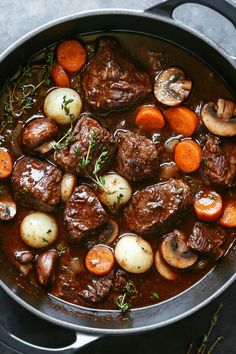 a pot filled with meat and vegetables on top of a table