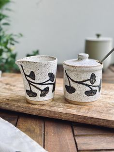 two ceramic cups sitting on top of a wooden table