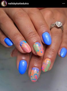 a woman's hand with blue and pink nail polish