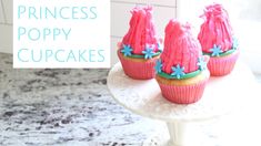 princess poppy cupcakes on a cake stand