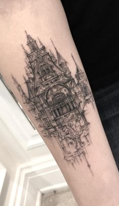 a black and white photo of a clock tower tattoo on the right arm with words top tatugens com