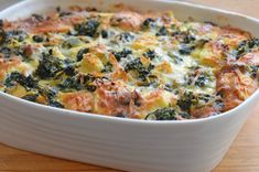 a casserole dish with cheese and spinach in it on a wooden table