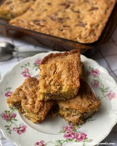 three pieces of cake on a plate next to a baking pan with a spoon in it