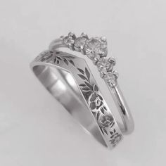 two silver rings with flowers and leaves on them, one has a diamond in the middle