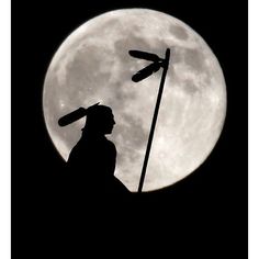 the silhouette of a man with a dragonfly on his shoulder stands in front of a full moon