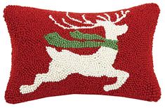 a red pillow with white and green reindeer on it