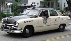 an old police car driving down the street