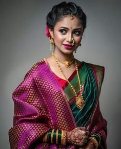 a woman in a purple and green sari with gold jewelry on her neck,