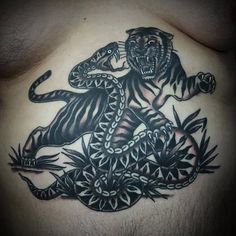 a man's chest with a tiger tattoo on it and an animal in the middle