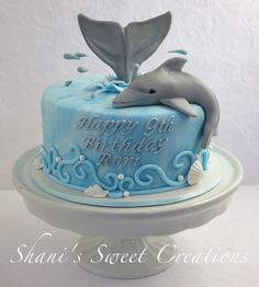 a blue birthday cake with a dolphin on top