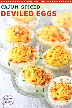 deviled eggs with sprinkles and seasoning in them on a glass platter