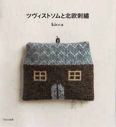 a knitted purse hanging on the side of a wall with words written in japanese