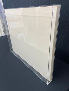 a clear acrylic display case on a black surface with white walls and flooring