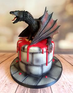 there is a cake with a dragon on top and red icing around the edges