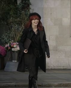 a woman with red hair walking down the street