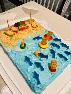 a birthday cake with blue icing and decorations on it's top, sitting on a table