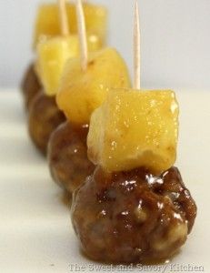 there are several skewers that have pineapples and meatballs on them