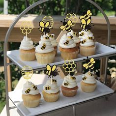 cupcakes with bee toppers on a cake stand