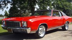 an old red car is parked on the street