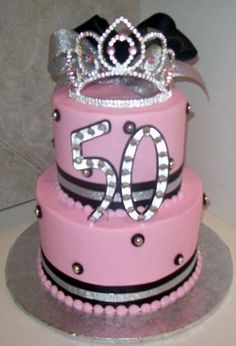 a pink cake with a tiara on top and the number 50 written in silver