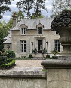 a large house with a big stone planter in front of the entrance to it