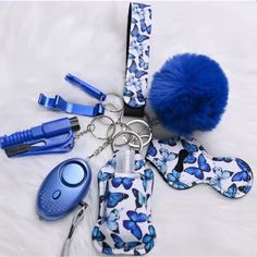 a blue pom - pom keychain and other items on a white sheet