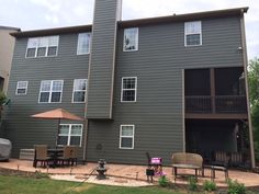 an apartment building with patio furniture and umbrella