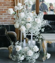 there is a vase with white flowers on the table