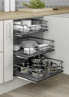 an open drawer in a kitchen filled with dishes