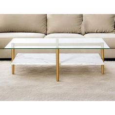 a glass table sitting on top of a white carpeted floor next to a couch