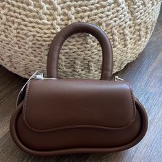 Meet Cici, The Epitome Of Fashion And Sustainability. This Small Round-Top Handle Bag, Made From Recycled Vegan Leather, Is Your Eco-Conscious Style Statement. Wear It Comfortably As A Crossbody Bag Using The Adjustable Strap For Hands-Free Convenience. Recycled Vegan Leather 9"W X 5"H X 3.25"D Handle Drop: 5" Strap Length: 37.5" Magnetic Snap And Zipper Closure Silver-Tone Hardware Lining Brown Satchel Baguette Bag With Handle Drop, Brown Baguette Satchel With Handle Drop, Brown Baguette Bag With Top Handle, Brown Crossbody Baguette Bag With Handles, Bucket Tote Bag, Melie Bianco, Vegan Leather Backpack, Faux Leather Top, Bucket Tote